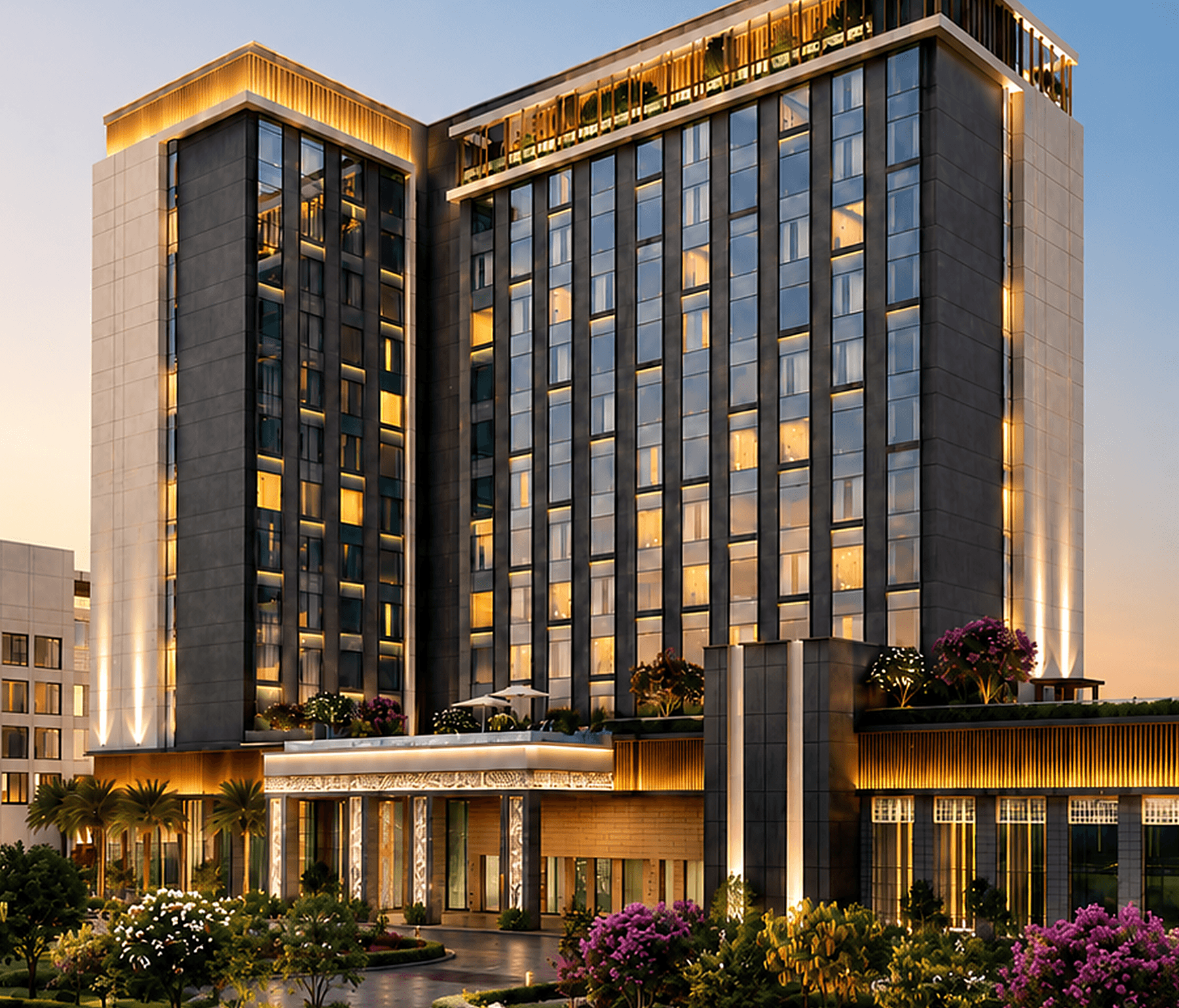 Sandal Suites Shirdi at dusk — the L-shaped all-suite hotel, warmly lit, with landscaped gardens in the foreground